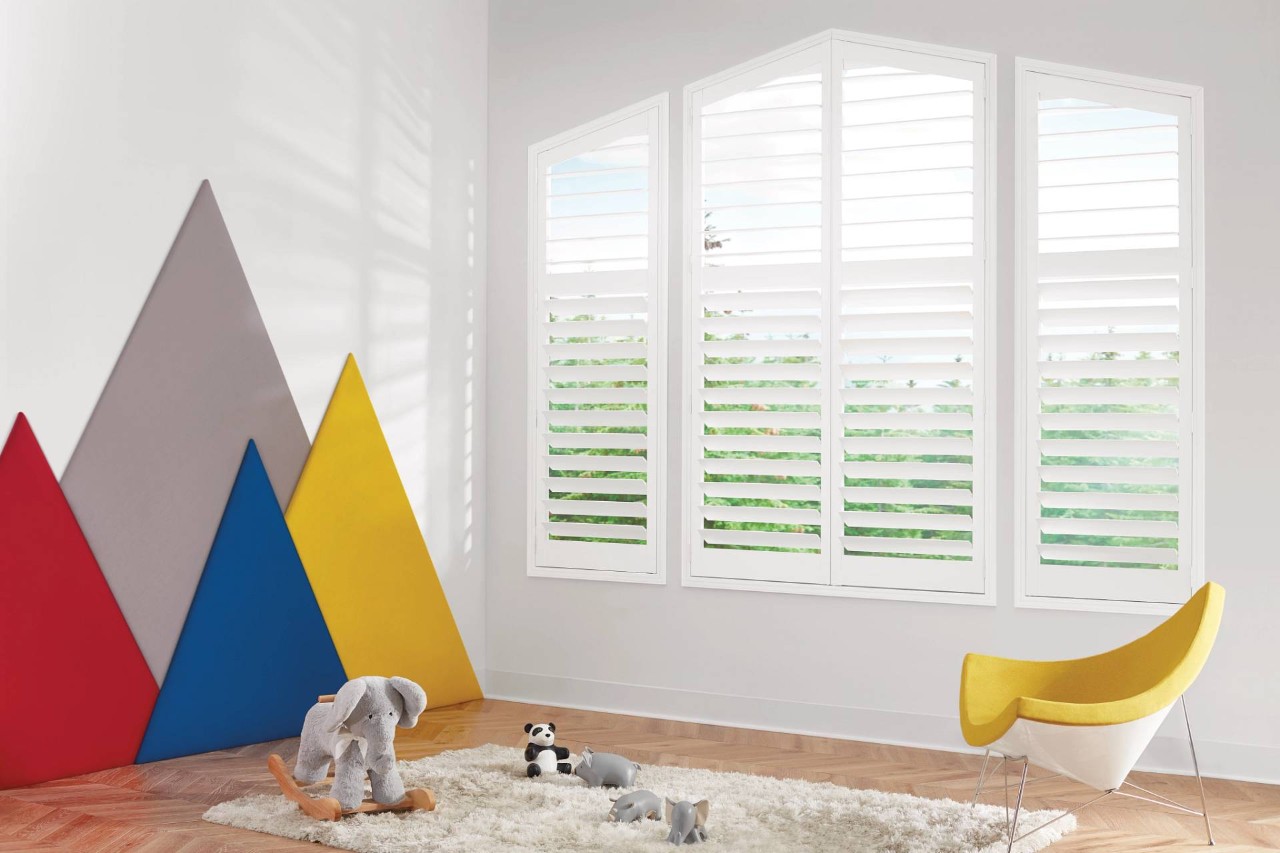 Hunter Douglas NewStyle® Composite Shutters on angled windows in a kid’s playroom near Newport News, Virginia (VA)