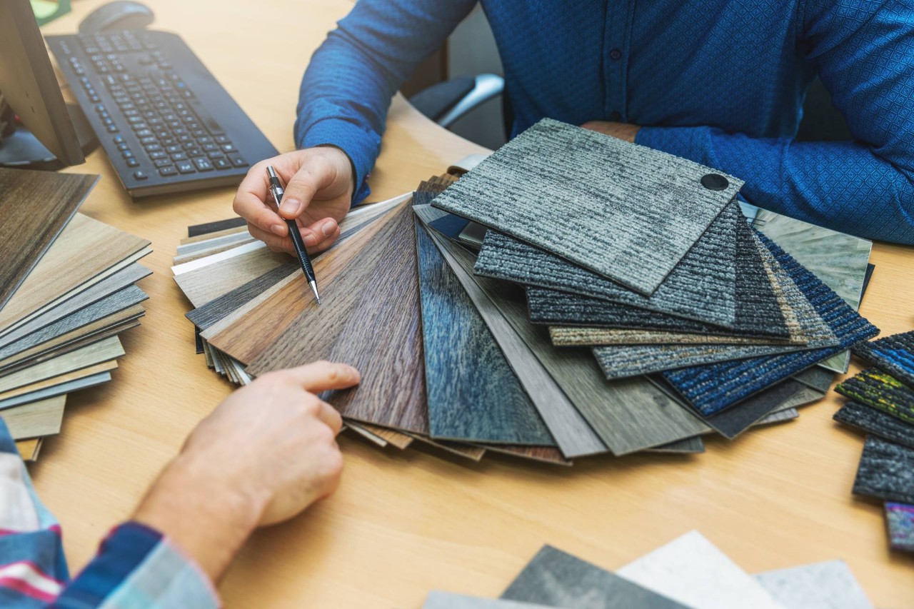 A designer showing a client different wood vinyl and carpet options near Newport News, Virginia (VA)