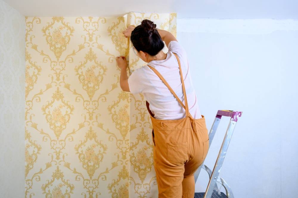 Someone applying custom yellow wallpaper to a wall near Newport News, Virginia (VA)