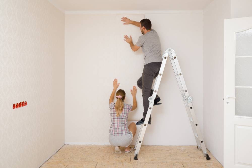 Someone applying custom yellow wallpaper to a wall near Newport News, Virginia (VA)